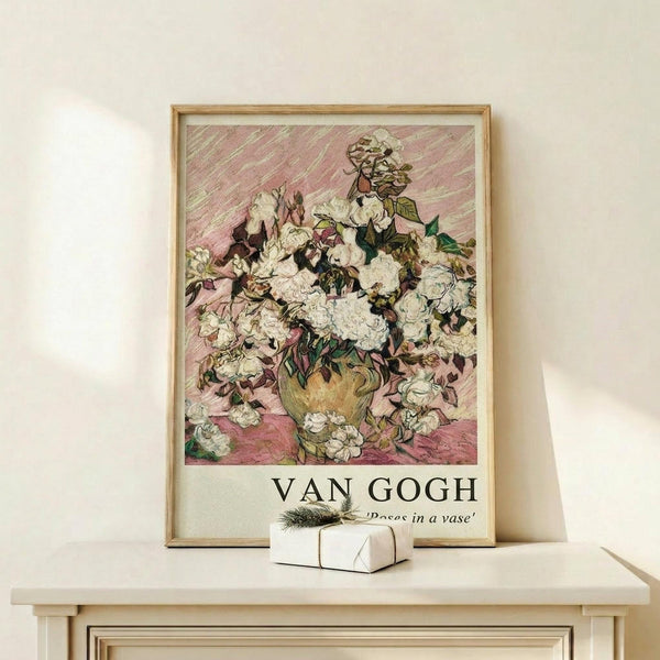 May include: Framed poster print of Van Gogh's white roses painting displayed on light wood surface against cream wall. The artwork shows abundant white roses with pink and green accents in an impressionist style with visible brushstrokes. Small wrapped white gift box with green sprig sits beside the natural wood frame.