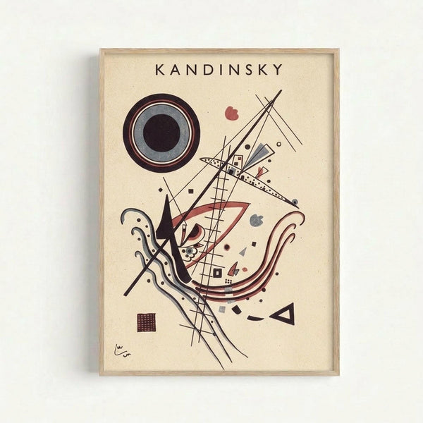 Framed abstract art print featuring geometric shapes and lines in black, red, and gray on cream background. Central composition includes concentric circles, triangular forms, curved lines, and scattered dots. Artist signature visible in bottom left corner. Minimal wooden frame displayed against white wall.