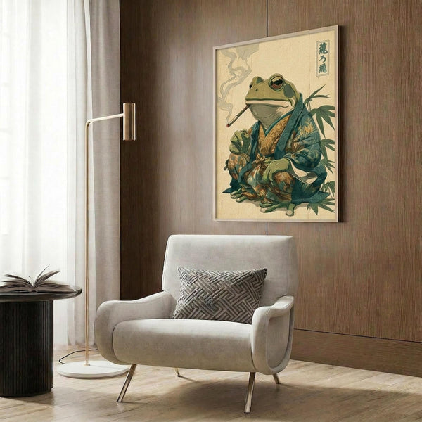 May include: Framed poster on wood-paneled wall showing a green frog in traditional Japanese kimono smoking a pipe, rendered in vintage ukiyo-e art style with Japanese characters. Modern beige armchair with geometric pillow sits below, alongside brass floor lamp and dark round side table with open book.