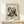 May include: Framed Kandinsky abstract art print displayed on light wood shelf against cream wall. The artwork features dynamic black lines, geometric shapes, and colorful elements in red, blue, yellow, and green on white background. Small wrapped gift box with evergreen sprig sits beside the thin wooden frame.