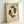 May include: Framed poster print leaning against white wall showing two black koi fish swimming in circular yin-yang formation on aged cream background with Chinese characters and "LOSE YOUR MIND, FIND YOUR SOUL" text at bottom. Light wood frame with natural grain visible, soft natural lighting creating gentle shadows.