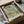 May include: Vintage botanical art print with intricate green foliage, orange and pink flowers in ornate William Morris style pattern, displayed in black frame inside cardboard shipping box with protective tissue paper wrapping on white surface