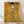 May include: Framed reproduction of Gustav Klimt's golden portrait painting showing an elegant woman in an ornate gold dress with geometric patterns and swirling designs, displayed in a light wooden frame against white walls on wooden flooring with natural sunlight streaming across the scene.