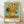 May include: Framed poster print of Van Gogh's famous sunflowers painting displayed on wooden floor against white wall. The artwork shows vibrant yellow sunflowers in a yellow ceramic vase against turquoise background, with thick expressive brushstrokes characteristic of post-impressionist style. Natural wood frame surrounds the print, which includes "VAN GOGH" and "Sunflowers, 1888" text below the image.