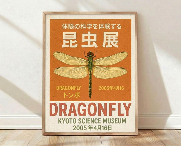 May include: A framed vintage-style poster with orange background featuring a detailed dragonfly illustration with transparent wings and segmented body. Japanese text appears at top, with "DRAGONFLY" and "KYOTO SCIENCE MUSEUM 2005年4月16日" below. The wooden-framed print leans against a white wall on light wooden flooring with natural lighting casting soft shadows.