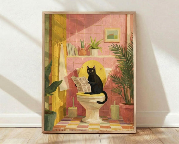 May include: Framed illustration print leaning against white wall on wooden floor. Artwork shows black cat sitting on toilet reading newspaper in colorful bathroom with pink tile walls, yellow curtain, green plants on shelf, small framed picture, and checkered floor. Warm lighting creates shadows on wall. Natural wood frame surrounds the whimsical domestic scene rendered in soft, muted tones.