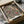 May include: Ornate floral poster print in shipping box with tissue paper wrapping. Features intricate Victorian-style botanical design with roses, chrysanthemums, and flowing foliage in rich burgundy, gold, and cream tones against dark background. Black-framed artwork shown nestled in brown cardboard packaging on white surface with soft natural lighting.