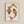May include: Two koi fish arranged in a circular yin-yang pattern, printed in warm reddish-brown ink on cream-colored textured paper. The fish feature detailed scales and flowing fins, displayed in a light wooden frame against a neutral beige wall. The artwork has a minimalist, Japanese-inspired aesthetic with visible paper texture and natural fiber specks.