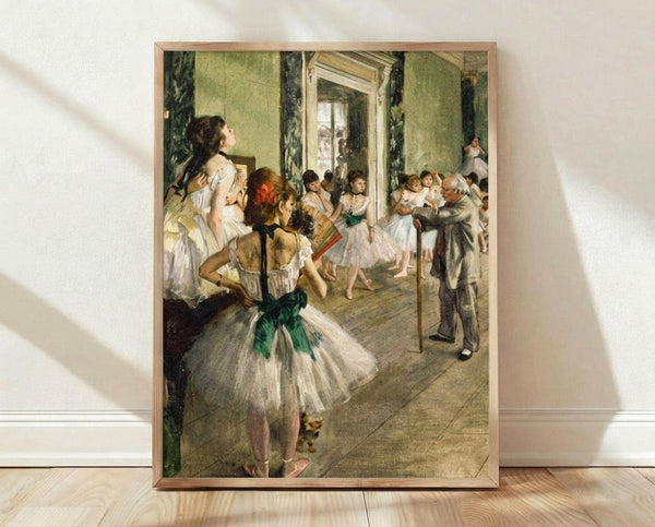May include: Framed reproduction of Degas ballet painting showing young dancers in white tutus with green sashes practicing in an ornate green-walled studio room, with an instructor holding a cane. The artwork is displayed in a light wood frame against white walls on wooden flooring, with natural lighting creating soft shadows across the scene.