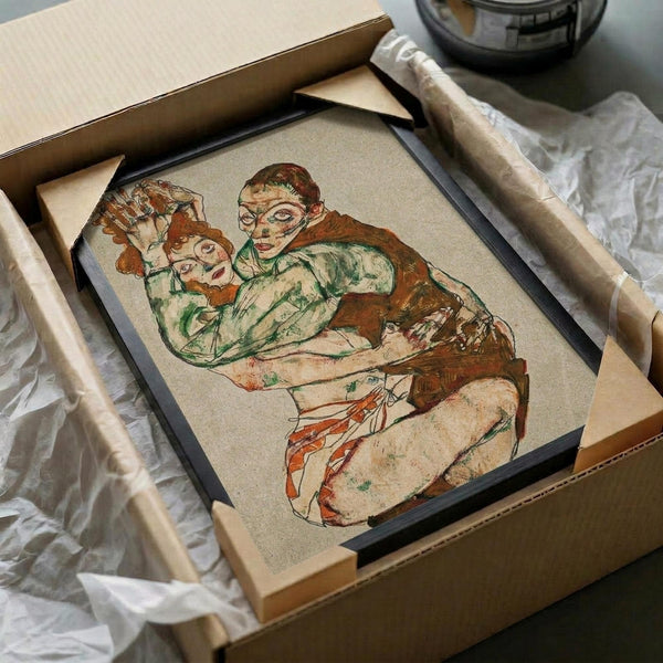 May include: Framed reproduction of an expressionist drawing showing two embracing figures rendered in earthy tones of brown, green, and orange against a cream background. The artwork sits in a black frame inside an open cardboard shipping box surrounded by protective packaging materials and wooden supports.