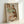 May include: Framed reproduction of an early 20th century expressionist drawing showing two embracing figures rendered in loose, gestural lines with muted green, brown, and red tones. The artwork is displayed in a simple light wood frame leaning against a white wall, showcasing the intimate, angular style characteristic of Austrian expressionist art.