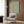 May include: Matisse poster print with yellow coral-like cutout design on sage green background, displayed in modern reading nook with beige upholstered chair, geometric throw pillow, brass floor lamp, and wood-paneled wall. Frame appears light wood with clean lines.