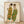 May include: Framed reproduction of an expressionist drawing showing two elongated figures in flowing green and golden robes with dark hair, rendered in sketchy lines against cream paper. The wooden frame sits on light hardwood flooring against a white textured wall with diagonal shadows.