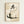 May include: Framed artwork hanging on beige wall showing minimalist ink painting of plump sitting cat in muted gray and beige tones with black Japanese calligraphy character above, displayed in light wood frame against textured aged paper background with subtle ink splatters