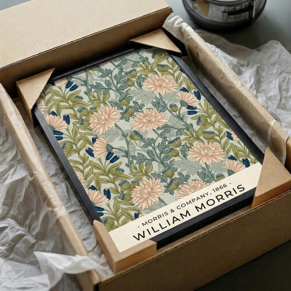 May include: Framed botanical print with vintage floral pattern featuring pink chrysanthemums, green foliage, and blue accents on cream background. Black frame displayed in cardboard packaging box with tissue paper wrapping. Print shows "Morris & Company 1866" and "William Morris" text at bottom.