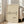 May include: Framed art print featuring a minimalist black line drawing of a dachshund dog on cream textured paper background with "Picasso" signature below. Light wooden frame displayed on wooden floor next to beige upholstered sofa in bright living room with white walls and large windows.