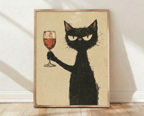May include: Framed poster print featuring a black cat with white eyes holding a wine glass filled with red wine. The cat has a textured, sketchy appearance against a cream background. Wooden frame sits on light wooden flooring against white wall with natural lighting casting shadows.