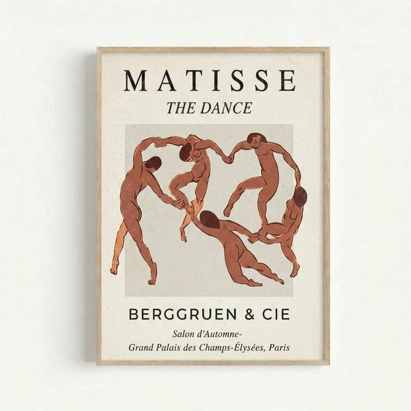 A framed art print featuring Matisse's "The Dance" with stylized nude figures in terracotta red holding hands in a circle against a cream background. The poster includes black text reading "MATISSE", "THE DANCE", "BERGGRUEN & CIE" and French exhibition details. The print has a light wood frame and is displayed against a white wall.