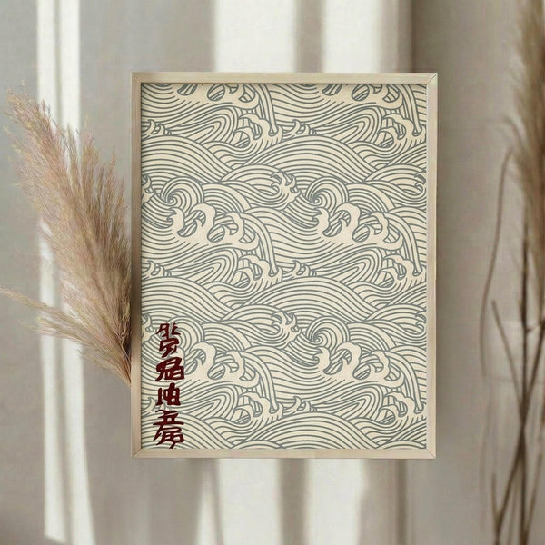 May include: Framed wall art displaying an intricate repeating pattern of flowing ocean waves in traditional Japanese style, rendered in sage green lines on cream background with red vertical Japanese characters in lower left corner. Light wood frame hangs on white wall beside dried pampas grass stems creating warm, minimalist home decor scene with natural lighting.