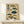 May include: Framed vintage-style Japanese scientific illustration featuring eight detailed pufferfish in various colors including brown, green, and teal, with traditional Japanese calligraphy and red stamps on aged beige paper, displayed on a light wood shelf beside a small white gift box with dark ribbon against a cream wall.
