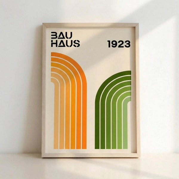 May include: Framed poster with cream background featuring "BAUHAUS 1923" in bold black letters at top. Two sets of curved concentric lines create arch shapes - orange gradient arches on left transitioning from deep orange to pale yellow, green gradient arches on right in various shades from dark to light green. Light wood frame against white wall with soft natural lighting.