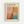 Framed poster with cream background featuring abstract artwork in coral, orange, and teal rectangular color blocks. Black text at top reads "MARK ROTHKO" with gallery information below. Exhibition dates "April 15 - July 30, 2023" and "6:00 PM" shown at bottom. Light wood frame against white wall.