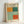 May include: Framed exhibition poster featuring Mark Rothko's abstract color block artwork in orange, teal, mint green, and coral rectangles on cream background. Poster displays gallery information and exhibition dates April 15 - July 30, 2023. Light wood frame leans against white wall, showing museum-style typography and minimalist design with soft natural lighting.