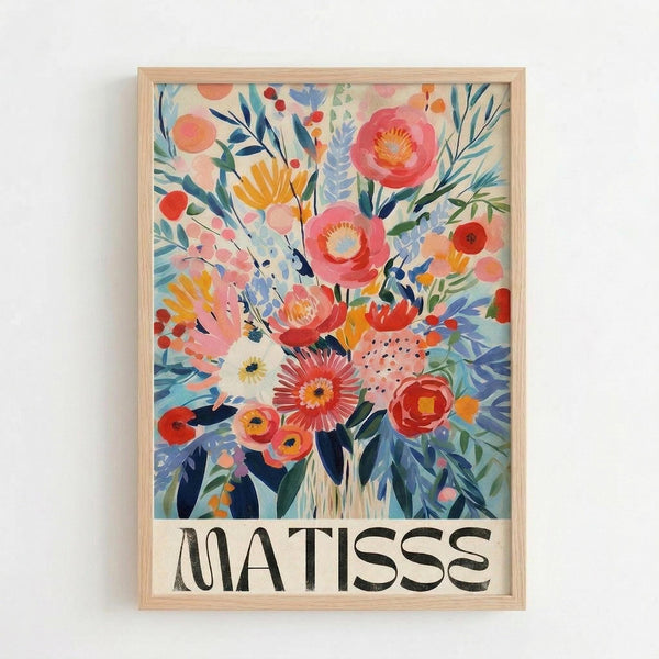Colorful floral art print in light wood frame hanging on white wall. Vibrant bouquet features pink, coral, yellow and orange flowers with blue and green foliage in painterly style. Bold black "MATISSE" text appears at bottom on cream background. Botanical illustration shows layered blooms, leaves and berries in warm, saturated colors with artistic brushstroke textures.