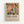 Framed poster featuring vibrant botanical illustration with stylized flowers and leaves in orange, pink, green, and blue colors on cream background. Bold black text below reads "Matisse: A Master of Color and Form" followed by exhibition description. Light wood frame against white wall in gallery-style presentation.