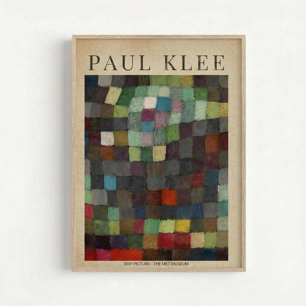 Framed art print featuring Paul Klee's abstract mosaic composition of colorful squares in muted greens, blues, purples, oranges, and earth tones arranged in a grid pattern. The artwork is displayed in a light wood frame against a cream colored mat, with "PAUL KLEE" at the top and "MAY PICTURE - THE MET MUSEUM" at the bottom. The frame hangs on a white wall, casting a subtle shadow.