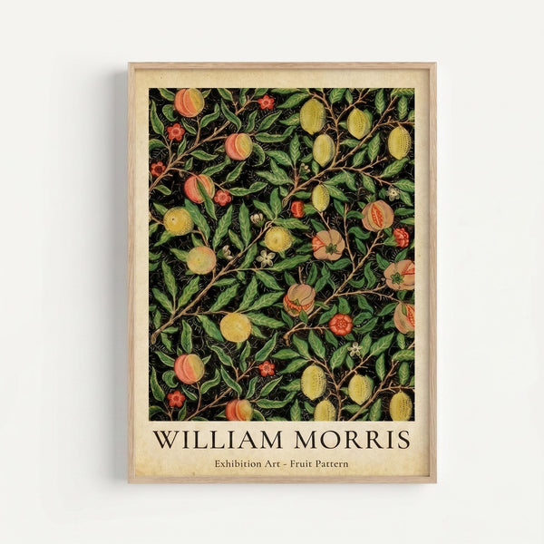 A framed botanical art print featuring William Morris's intricate fruit pattern design with peaches, oranges, and other fruits among lush green foliage on a dark background. The artwork is displayed in a natural wood frame with cream matting against a white wall. The vintage-style botanical illustration shows detailed leaves, branches, and colorful fruits in Morris's characteristic decorative style.