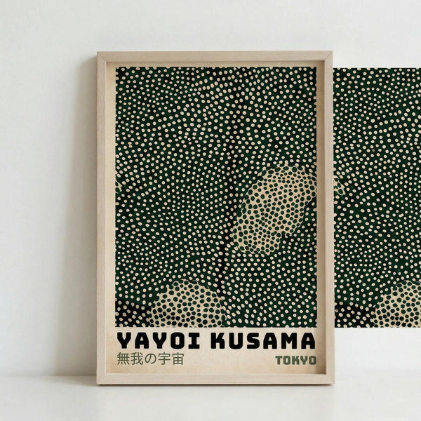 May include: Framed poster print with green background covered in white dots creating polka dot pattern. Two circular areas show cream-colored sections with black dots in reverse pattern. Bottom text reads "YAYOI KUSAMA" in black letters with Japanese characters below and "TOKYO" on right. Light wood frame against white wall, part of second similar frame visible on right edge.