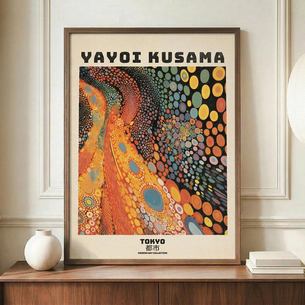 May include: Framed art print with colorful abstract polka dot pattern in orange, yellow, and multicolored circles against black background, displayed on wooden console table next to white ceramic vase and stacked books in elegant room with white walls and molding.
