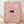 May include: Framed poster print leaning against white wall on light wood floor. Light wood frame contains artwork showing small black cat face with bright eyes peeking through dense field of pink and white daisy flowers. Soft natural lighting creates gentle shadows on textured white wall behind frame.