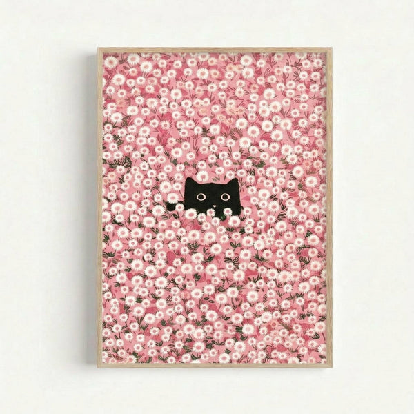 A whimsical illustration featuring a black cat with bright yellow eyes peeking through a dense field of pink and white daisy flowers. The cat's face and ears are visible among the blooms, creating a playful hide-and-seek effect. The artwork has a dreamy, romantic aesthetic with soft pink tones throughout the floral pattern. Displayed in a thin natural wood frame against a white wall.