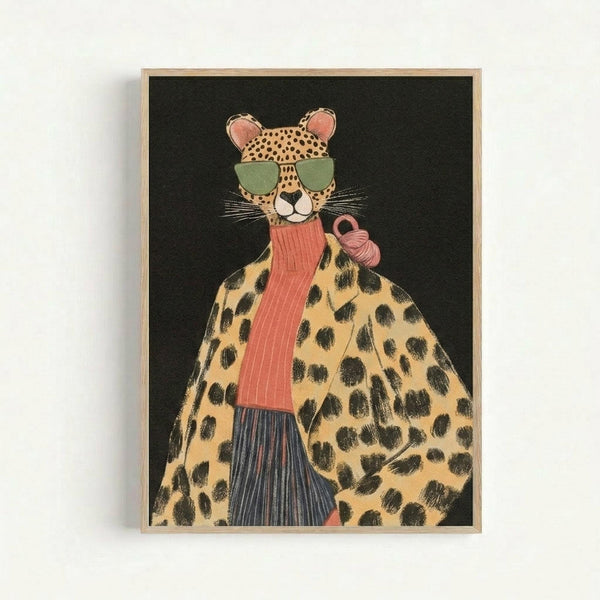 Illustration of an anthropomorphic cheetah wearing oversized green sunglasses and a coral pink ribbed scarf, depicted in a stylized fashion portrait style against a black background. The cheetah has spotted fur and is wearing what appears to be a leopard print coat over dark striped clothing. The artwork is displayed in a light wooden frame and has a whimsical, contemporary art aesthetic with warm yellow and pink tones.