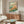 Whimsical nature poster displaying a songbird nestled in a wildflower meadow with impressionistic brushwork in soft pink, orange, and sage hues.