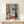 Modern impressionist framed print depicting a contemplative interior with palm trees, open doors, and warm Mediterranean color palette of ochre, terracotta, and blue.