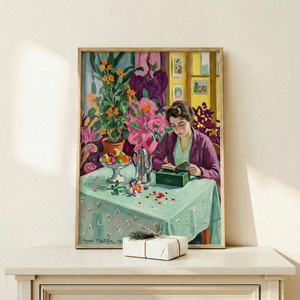 Framed poster of a girl engrossed in a book within a warmly-colored interior space, using rich jewel tones and decorative elements to convey peaceful contemplation.
