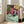 Framed artwork depicting a girl reading indoors in an Impressionist composition with luminous greens, reds, and whites capturing a quiet moment of concentration and comfort.