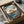 Japandi wall art in the style of Hiroshige depicting an introspective autumn scene with maple branch details, temple silhouette, and layered misty mountains in cool and warm tones.