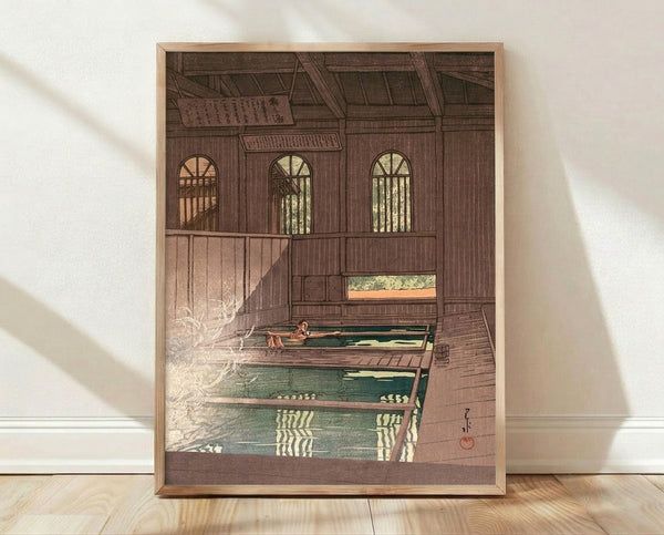 Serene Japanese woodblock print depicting a woman in a traditional bathhouse with warm brown and cream tones, framed on wall.