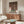 Showa-period inspired bathhouse interior art showing figure by water and windows, executed in gentle warm browns with touches of peach and green.