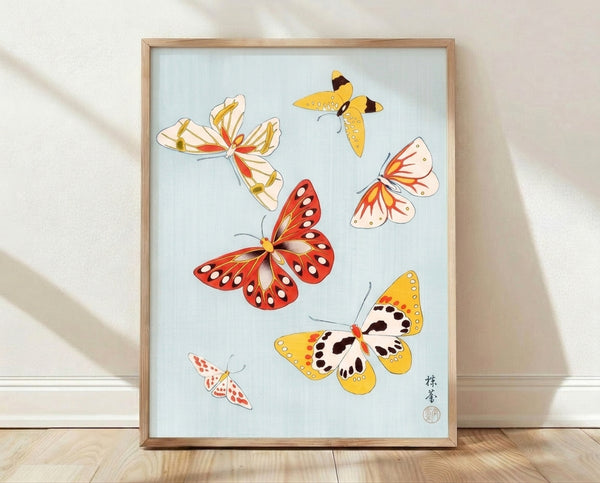 Framed Japanese woodblock poster featuring delicate butterflies rendered in red, gold, and pale blue with fine black line work, evoking a serene nature study.