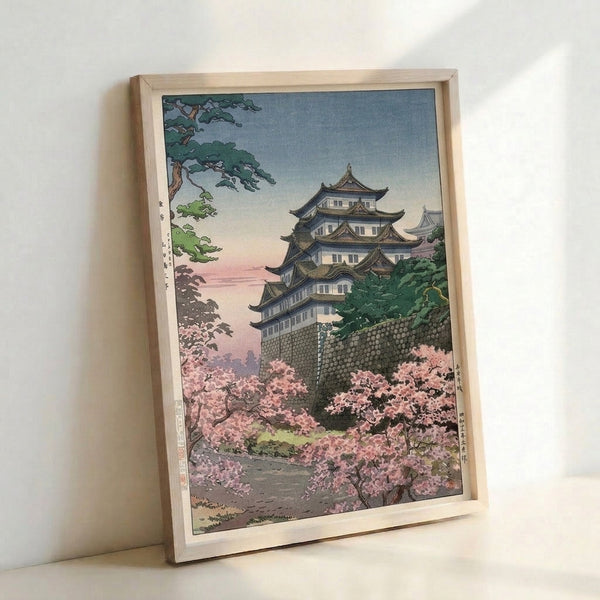 Tranquil Japanese castle scene in woodblock print style, featuring cherry blossoms in soft pink against pale blue sky, with gold accents and verdant foliage.
