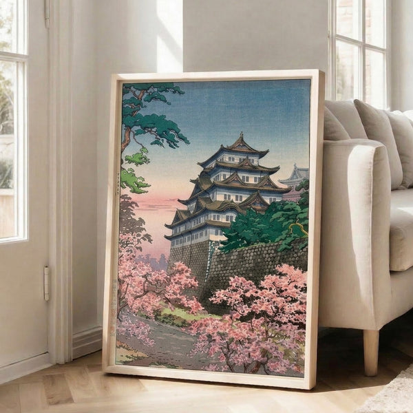 Pale blue and cream Japanese woodblock poster of a historic castle framed by elegant cherry blossoms and stone architecture in spring.
