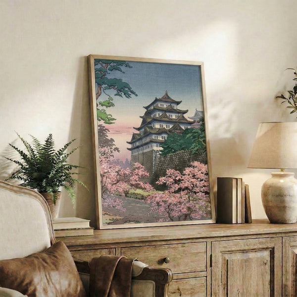 Contemplative Asian landscape art print in vintage woodblock style showing Nagoya Castle amid cherry trees, rendered in soft pastels with gold detailing.