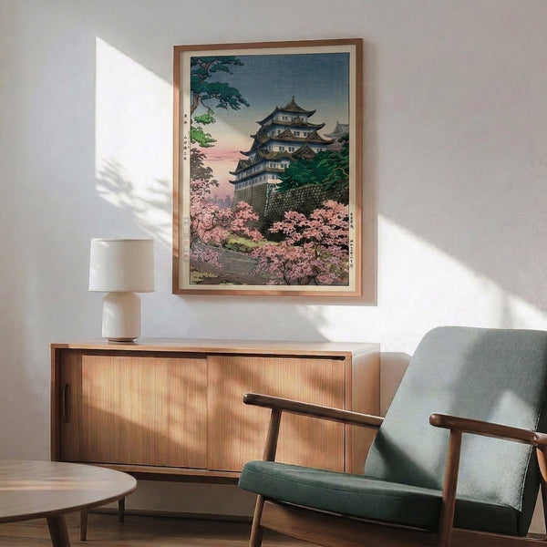 Framed woodblock-inspired poster capturing springtime serenity: a castle nestled among pale pink cherry blossoms with forest green trees in cream and gold palette.