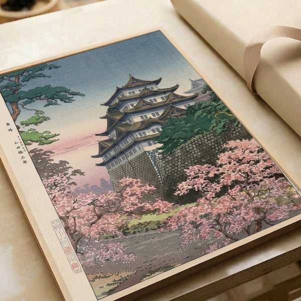 Japanese vintage woodblock art print of a castle landscape with cherry blossoms, stone walls, and forest green trees in soft blue, pink, and cream tones.