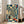 Meditative Japanese woodblock-inspired print showing ceramic vessels and boxes arranged in a receding corridor perspective, composed in soothing cream, teal, gold, and red lacquer colors.